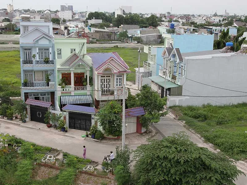 Kiêng Kỵ Nhà Gần Nghĩa Trang: Giải Pháp Hóa Giải Chuẩn Mực 5 Ngôi nhà phong thủy với hàng rào xanh trấn yểm.