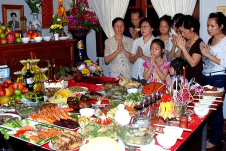 Gia đình quây quần bên mâm cỗ cúng Tết.