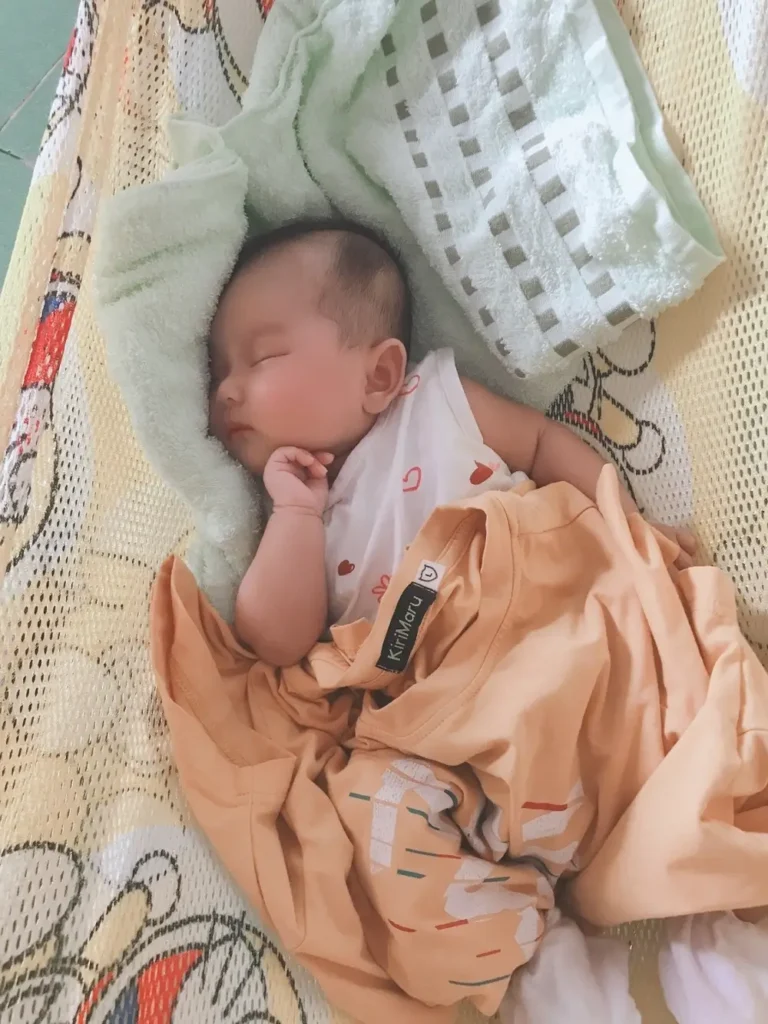 Hình ảnh em bé đáng yêu nằm trong nôi.