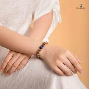 Vòng phong thủy trên tay, nền người suy tư.