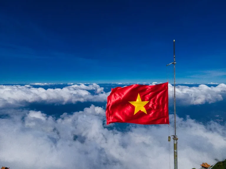 Quốc kỳ tung bay trên cột cờ trong nắng.