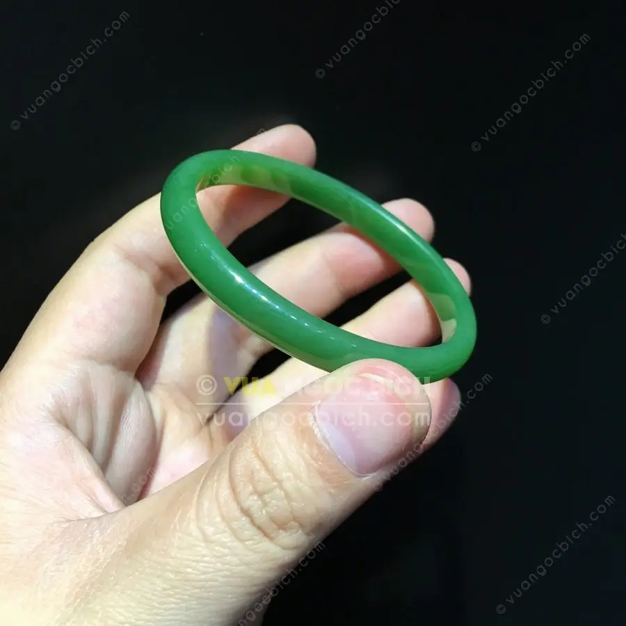 Bàn tay nâng niu vòng ngọc bích.