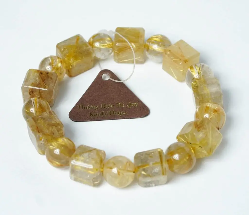 Vòng Thạch Anh Tóc Vàng Mệnh Nào: Hướng Dẫn Phong Thủy Toàn Diện 7 Bàn tay nâng niu vòng thạch anh tóc vàng.