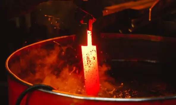 Thợ rèn tôi luyện kim loại trong lò lửa.