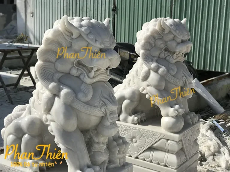 Cặp Kỳ Lân đá quý chạm khắc tinh xảo trên đôn gỗ.