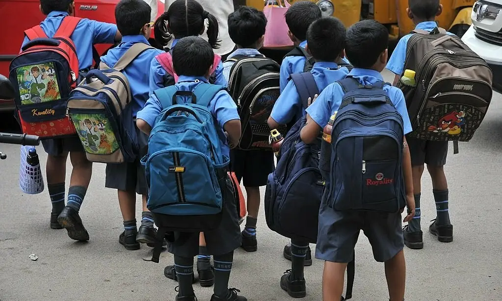 Học sinh suy tư, bên cặp sách cũ.