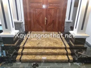Cửa chính có bậc tam cấp cân bằng độ cao nền.