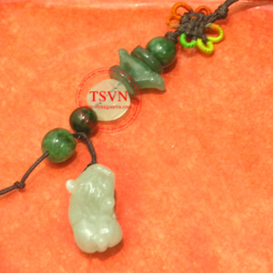 Điện thoại charm Tỳ Hưu trên sách phong thủy.