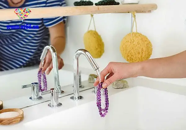 Rửa vòng thạch anh dưới vòi nước.