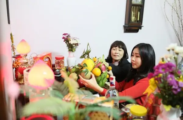 Phụ nữ thành kính lau dọn bàn thờ sạch sẽ.