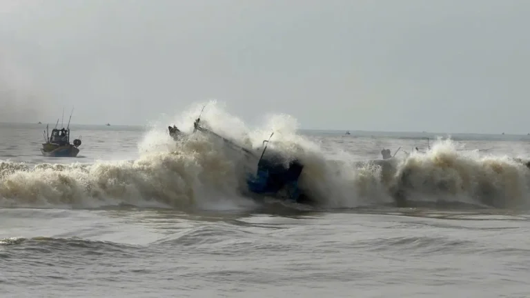 Xuồng chìm dần trên mặt nước gợn sóng.