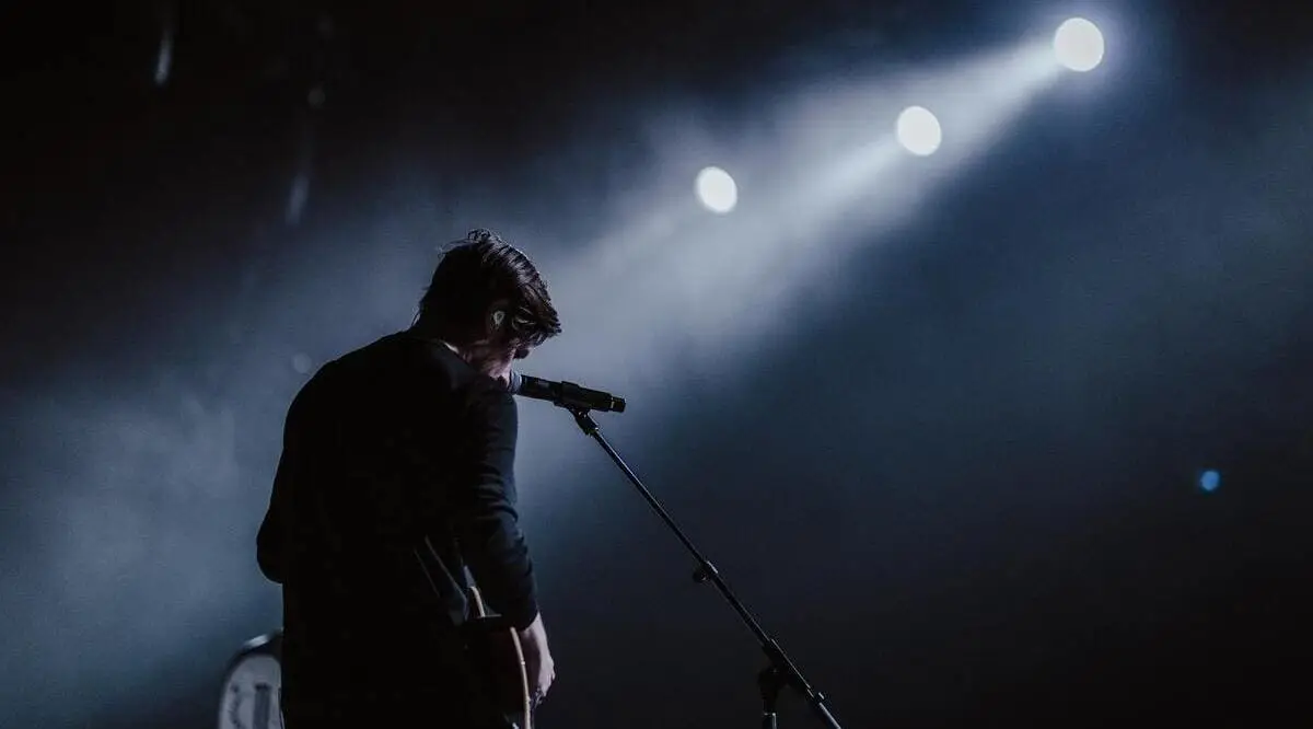 Nằm Mơ Thấy Mình Đứng Trên Sân Khấu Lớn: Giải Mã Điềm Báo Tâm Linh 4 Người đứng một mình trên sân khấu dưới ánh đèn.