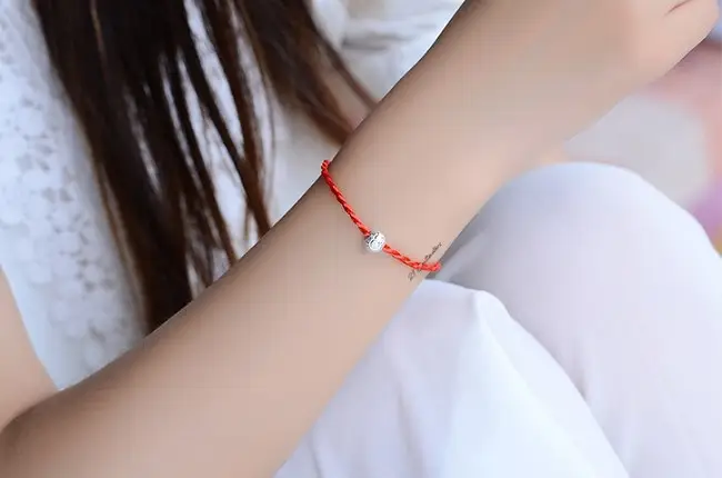 Vòng chỉ đỏ cầu duyên: Khai mở tình duyên đúng cách, hiệu quả 6 Tay dịu dàng đeo vòng chỉ đỏ dưới nắng.