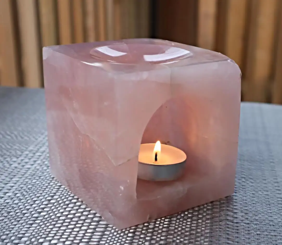 Vòng Thạch Anh Dâu Tây Cầu Duyên: Hướng Dẫn Kích Hoạt Năng Lượng Tình Yêu 6 Góc thanh tịnh, thạch anh dâu tây và nến.