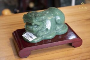 Tỳ Hưu đá cẩm thạch xanh lá trên bệ gỗ.
