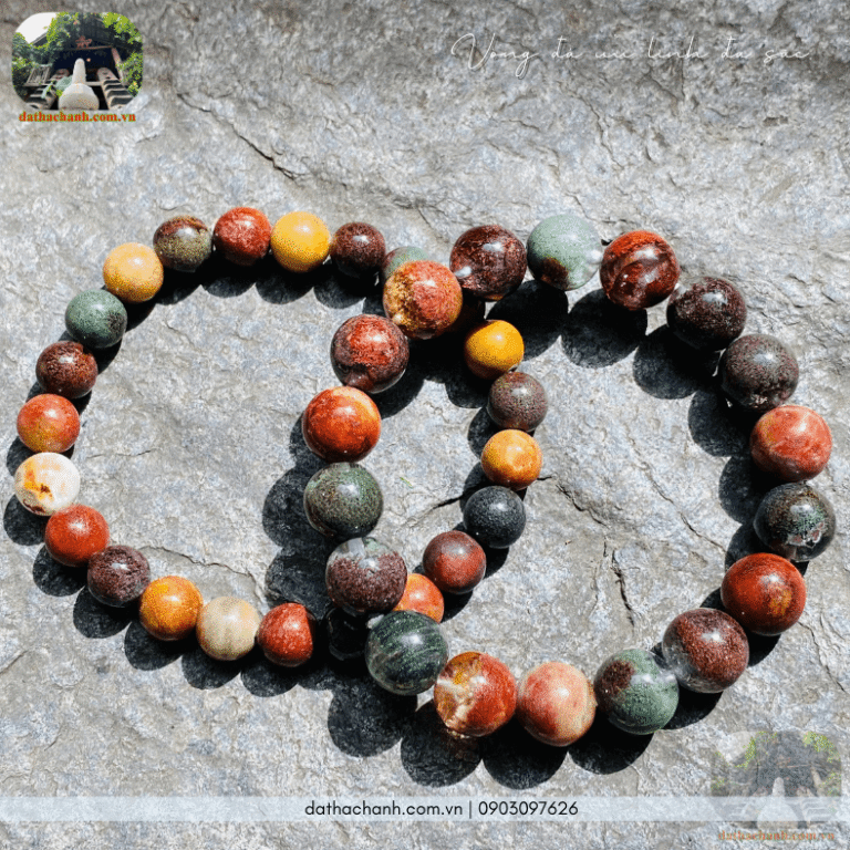 Vòng đá phong thủy đa sắc trên bàn gỗ thanh tịnh.