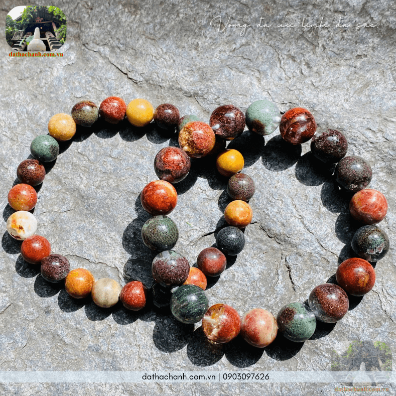 Vòng đá phong thủy đa sắc trên bàn gỗ thanh tịnh.