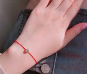 Vòng Chỉ Đỏ Nam Nữ Khác Nhau: Giải Mã Ý Nghĩa Và Cách Đeo Chuẩn Phong Thủy 7 Bàn tay trang trọng cầm vòng chỉ đỏ phong thủy.