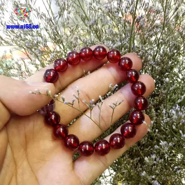 Vòng Garnet Tuổi Tỵ: Chìa Khóa Khai Mở Vận Mệnh Viên Mãn 4 Vòng Garnet đỏ thẫm trên gỗ, vải lụa.