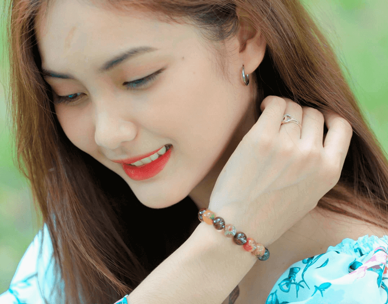 Vòng Phong Thủy Tuổi Dần: Chìa Khóa Khai Mở Tiềm Năng & Hóa Giải Vận Trình 6 Hình ảnh một người đang chọn lựa vòng đá, nhìn chăm chú và cảm nhận