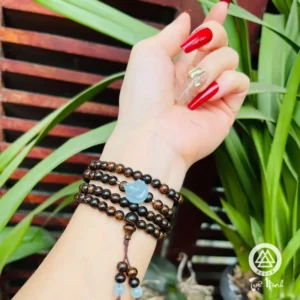 Phụ nữ trầm tư ngắm vòng thạch anh trên tay.