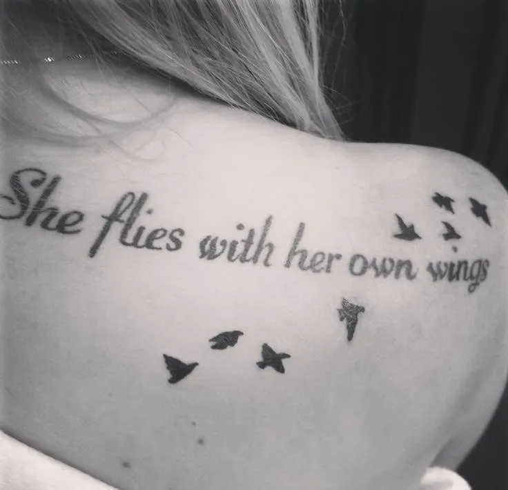 Hình xăm chữ tiếng Anh "She flies with her own wings" trên lưng, tượng trưng cho sự độc lập