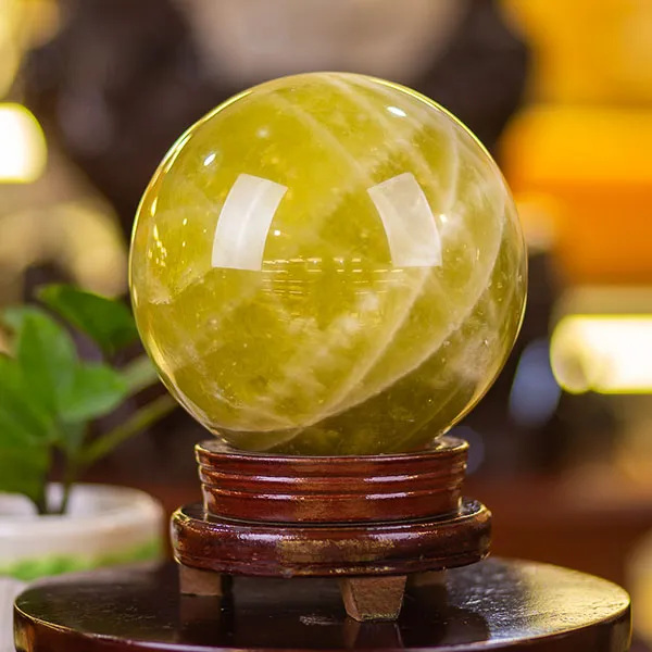 Quả cầu thạch anh màu vàng đặt trên đế gỗ phong thủy tinh xảo
