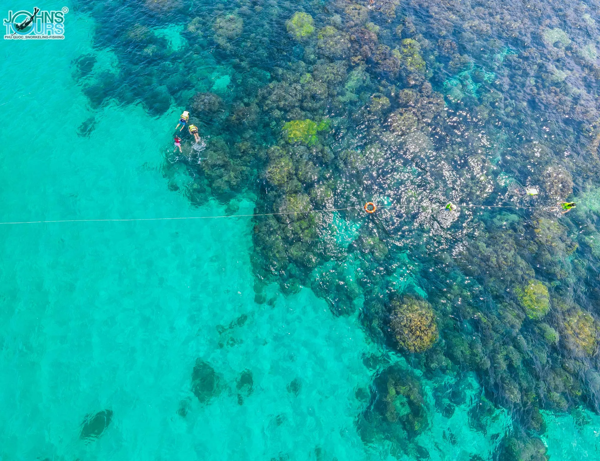 Du khách tham gia trải nghiệm lặn ngắm san hô bằng ống thở tại vùng nước nông