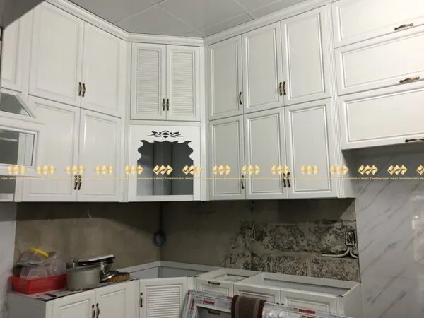 Mẫu tủ bếp kết hợp bàn thờ ông Táo bằng chất liệu nhôm giả gỗ màu trắng.