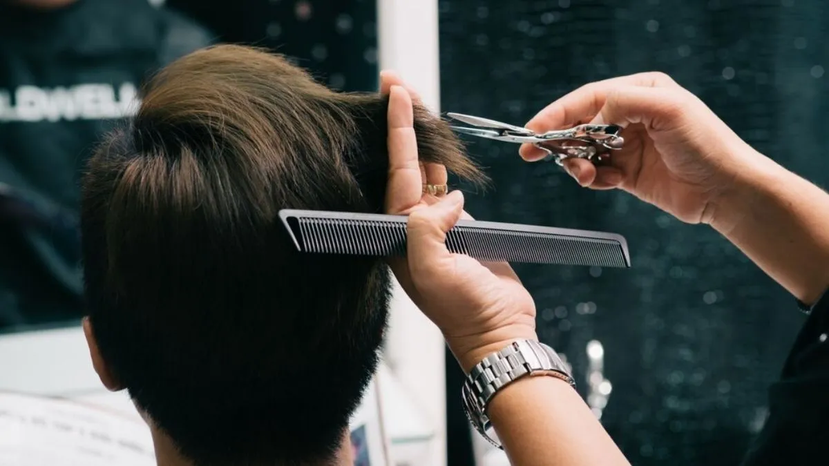 Người đàn ông đang được tạo kiểu tóc tại tiệm salon vào ngày hoàng đạo thuận lợi