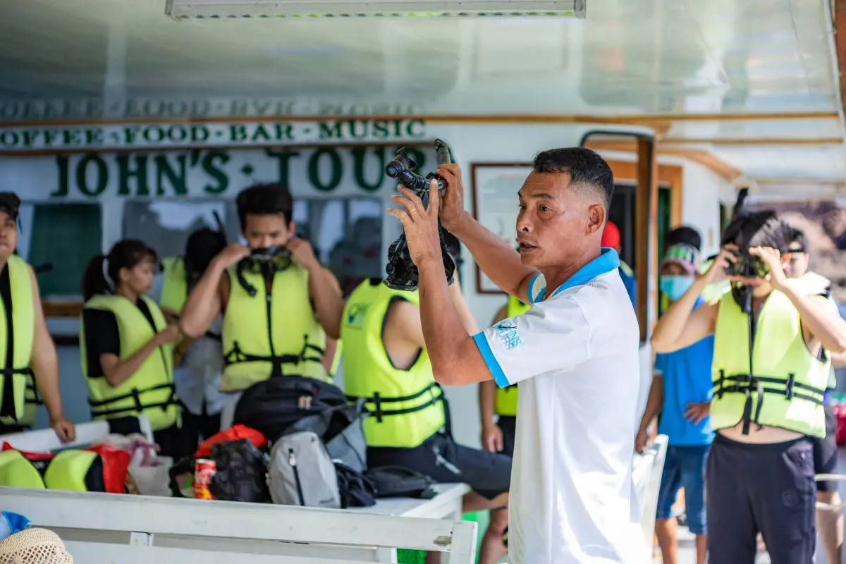 Hướng dẫn viên hướng dẫn khách hàng cách sử dụng thiết bị trước khi xuống nước